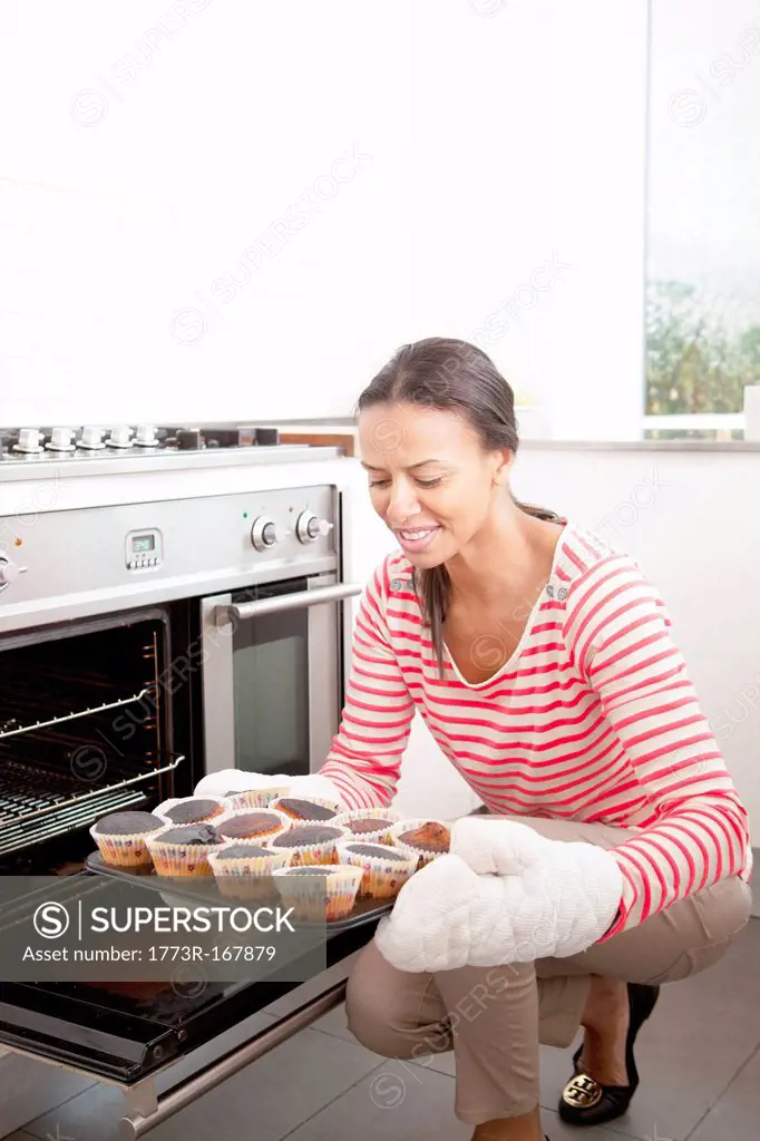 Woman holding tray of burned cupcakes