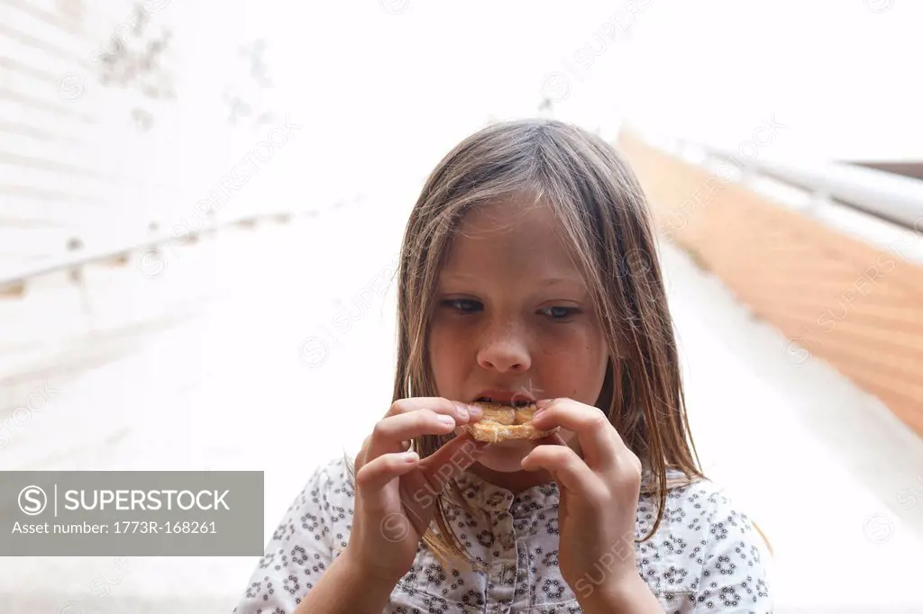 Girl eating cookie outdoors