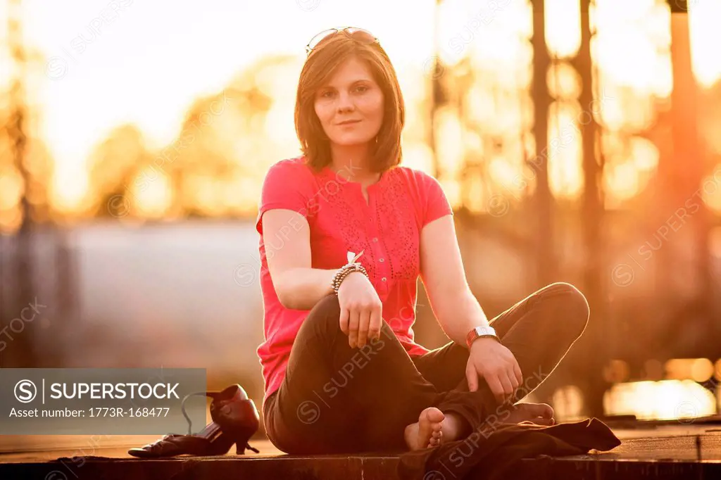Woman sitting cross_legged on stone wall