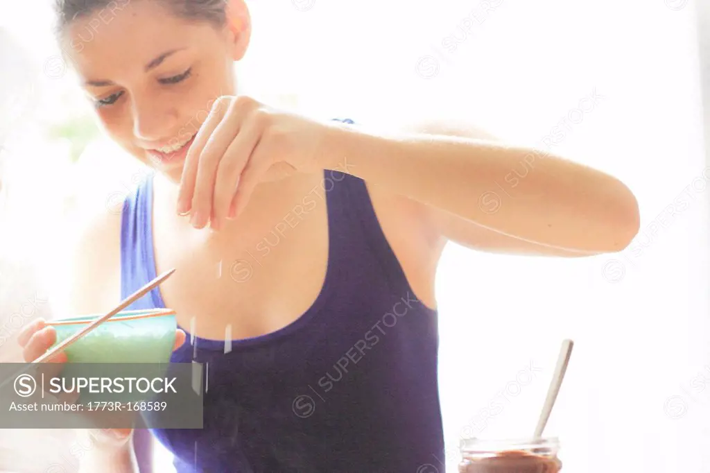 Teenage girl sprinkling salt on food