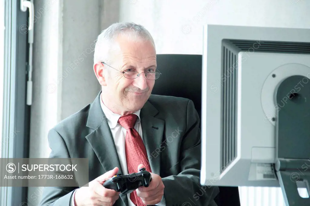 Businessman playing video games at desk