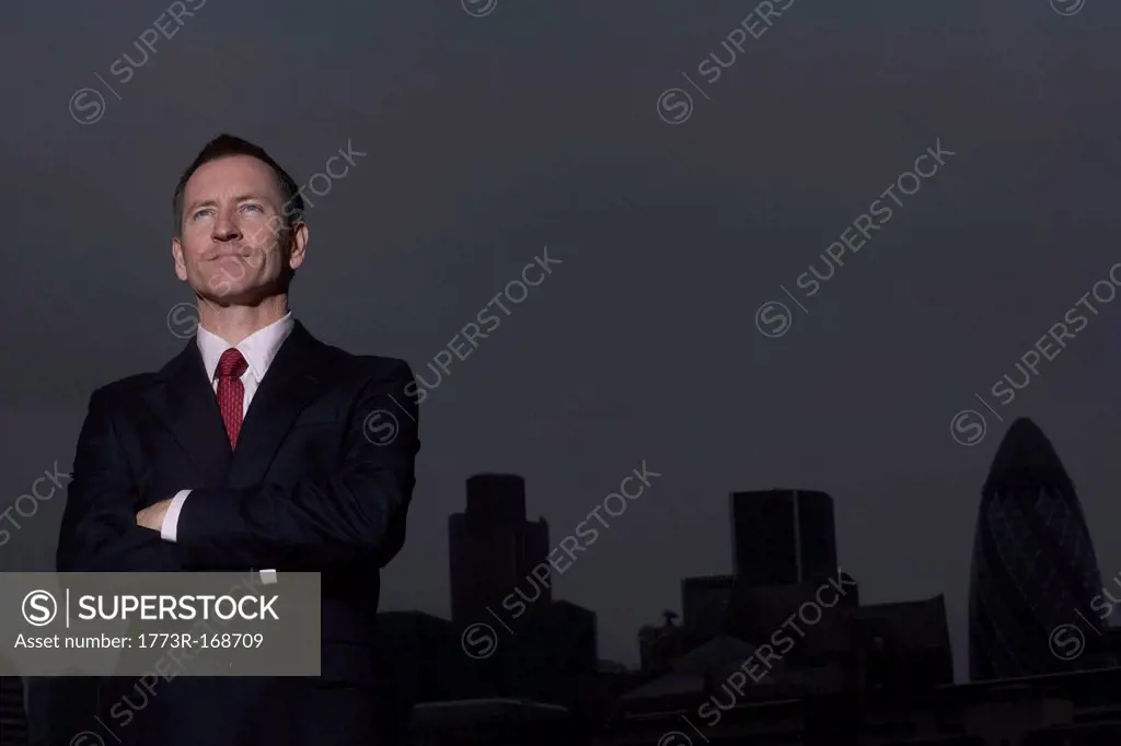 Businessman standing on urban rooftop