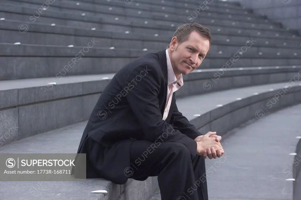 Businessman sitting on city steps