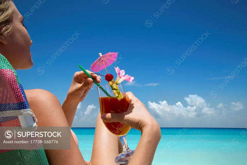 Woman with tropical drink on beach
