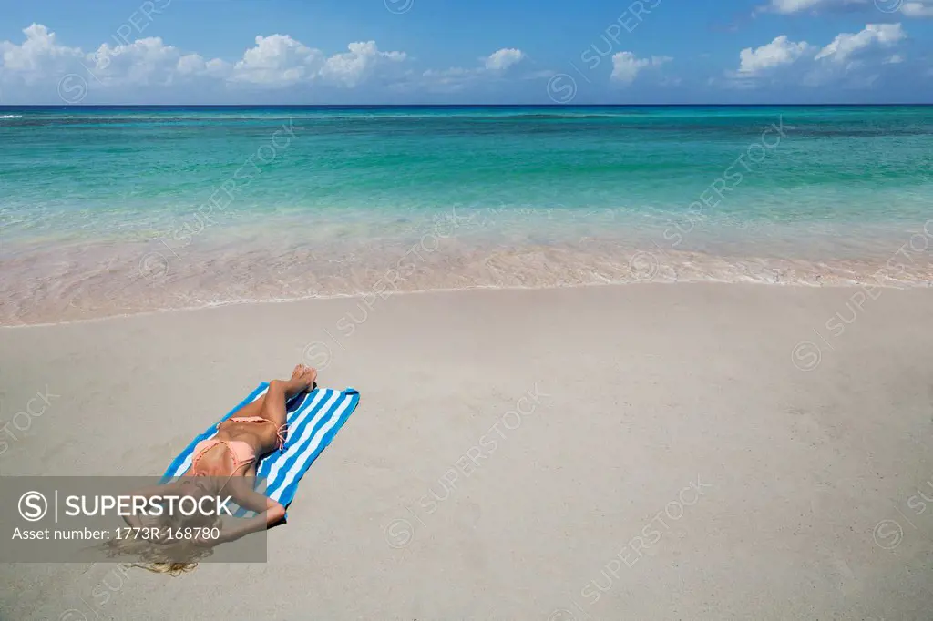 Woman laying on towel on beach