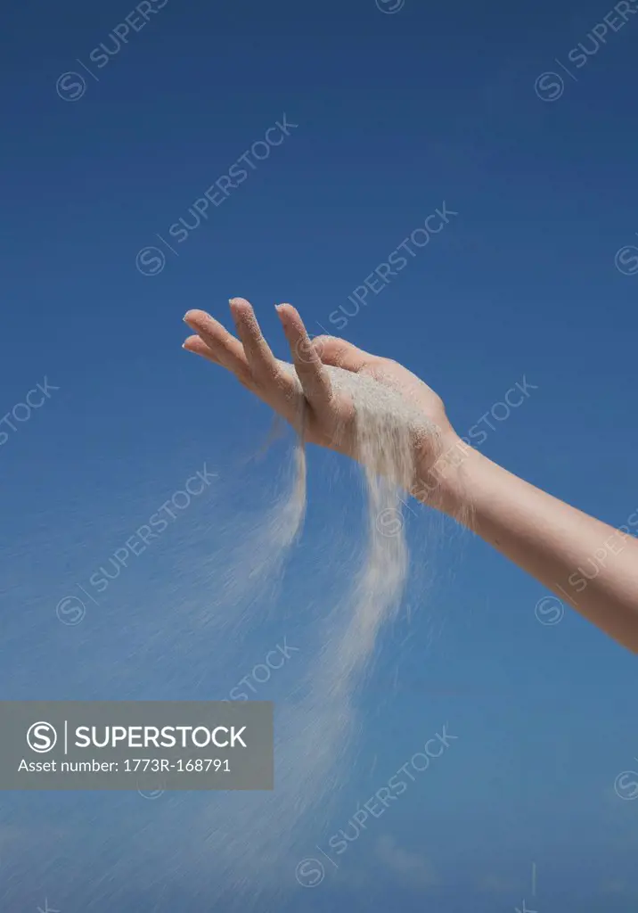 Close up of sand pouring from hand