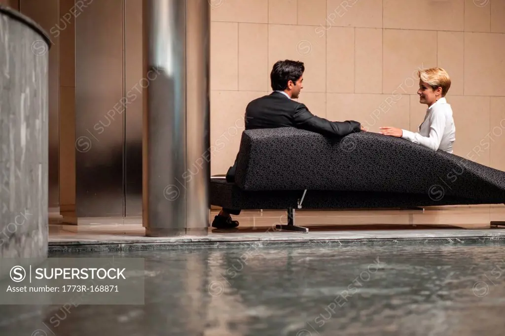 Business people talking on sofa in lobby