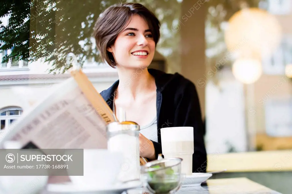 Woman reading newspaper in cafe