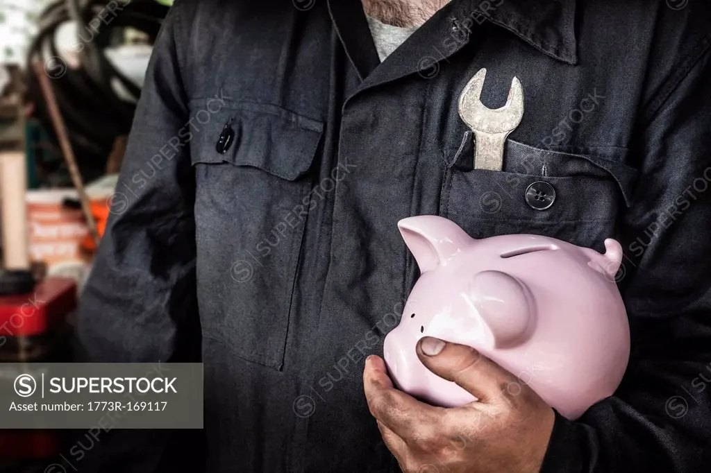 Close up of worker holding piggy bank
