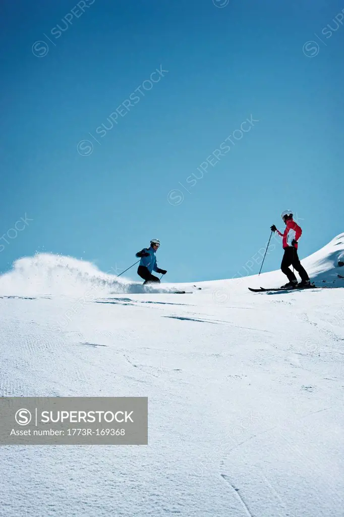 Skiers coasting on snowy slope