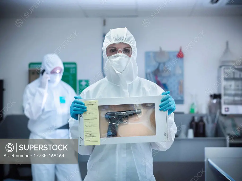 Forensic scientist with gun in box