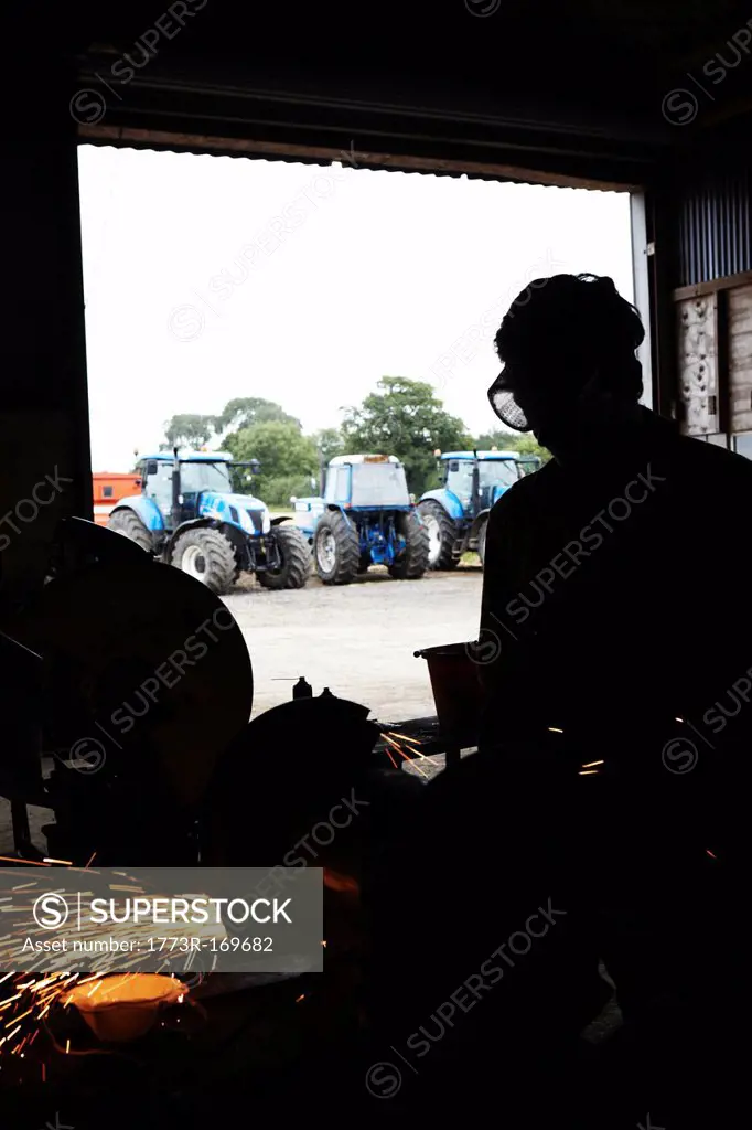 Silhouette of metal worker in shop