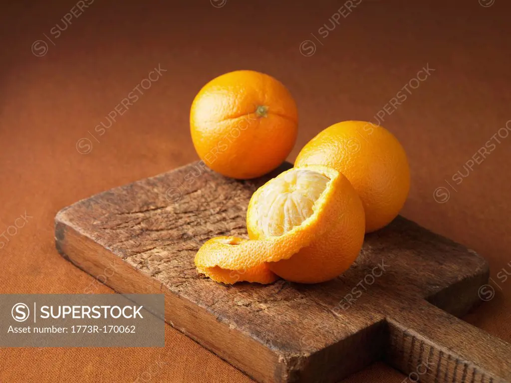Peeling orange on wooden board