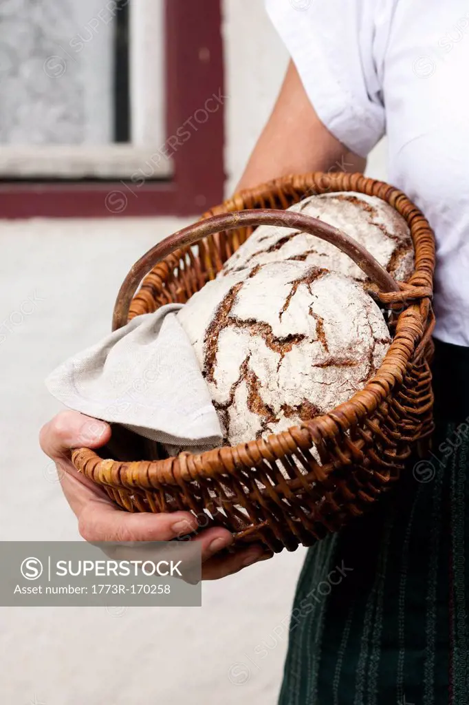 Man holding basket of sourdough bread