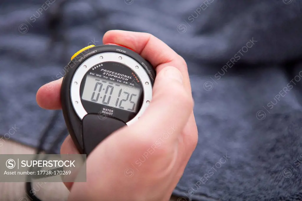 Close up of hand holding stopwatch