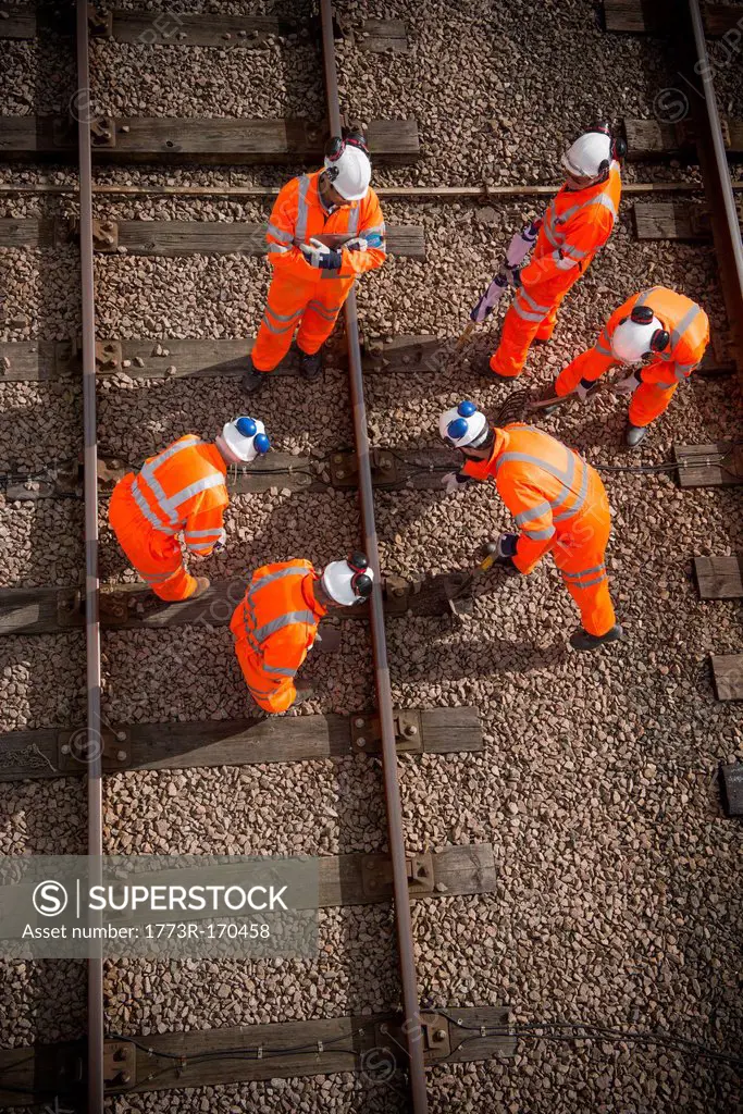 Railway workers examining train tracks