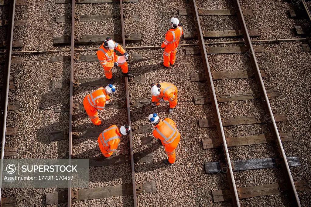 Railway workers examining train tracks
