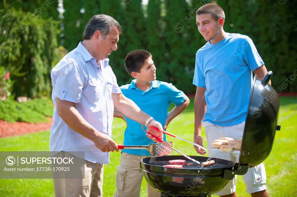 Father and sons grilling outdoors