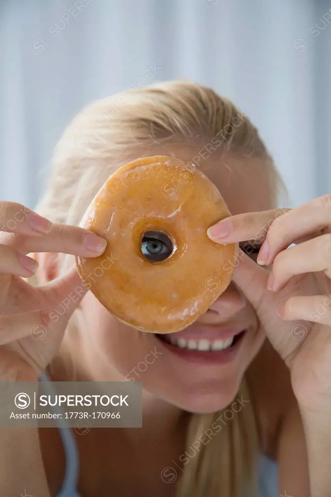 Woman peering through donut hole