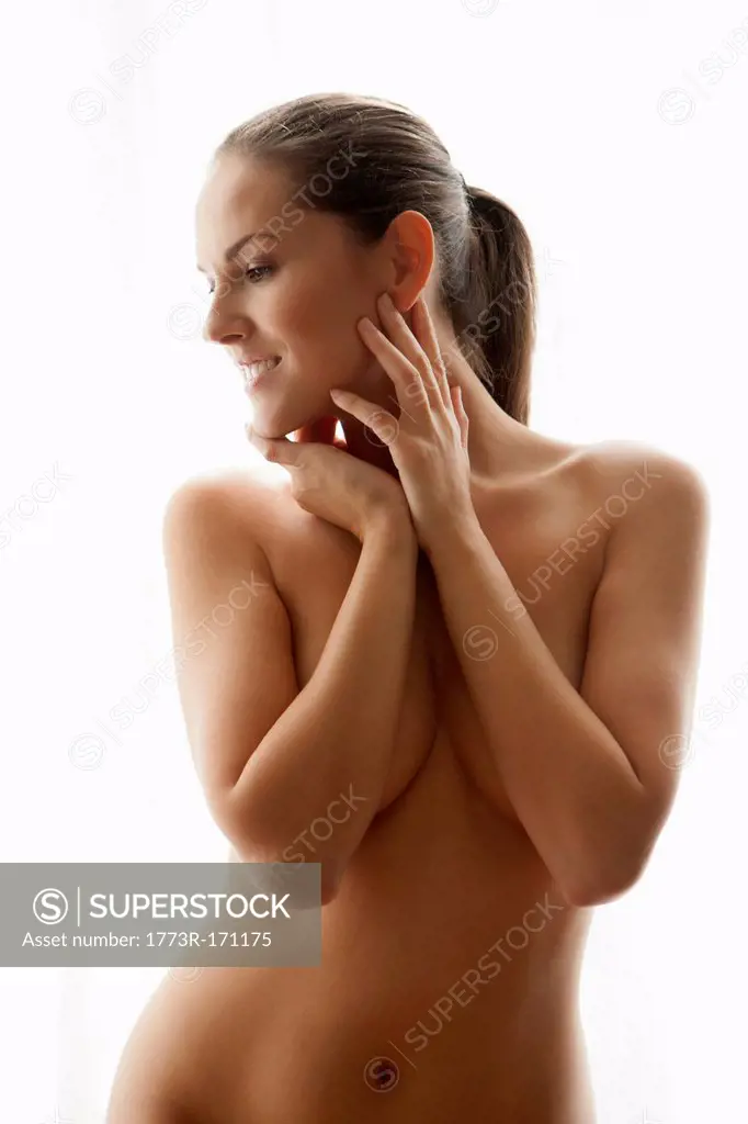 Nude woman covering her breasts