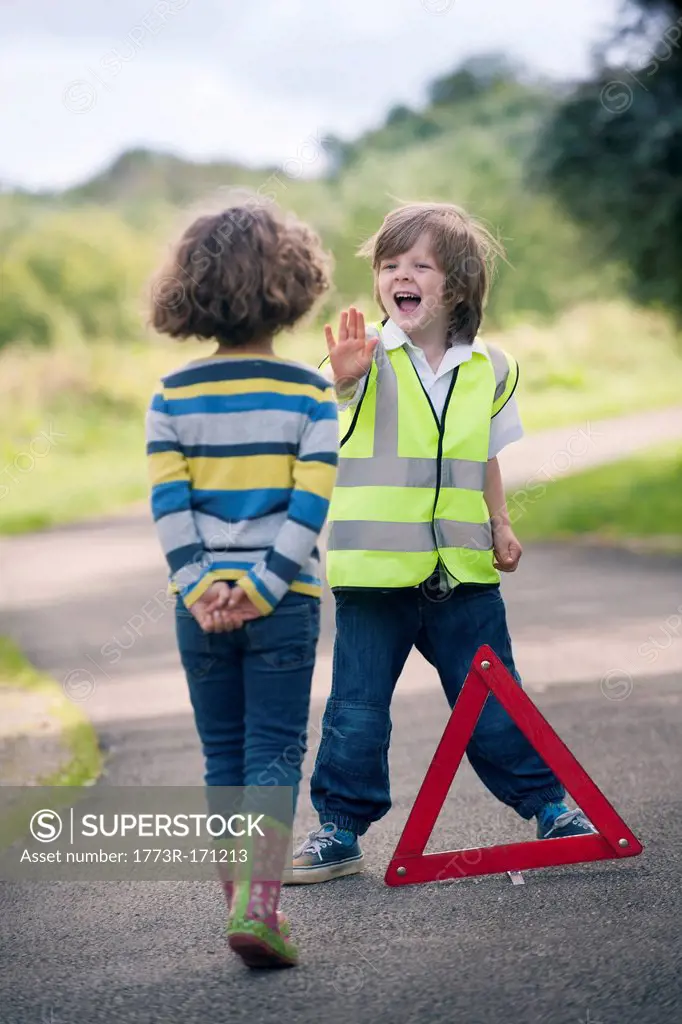 Boy playing traffic worker on rural road