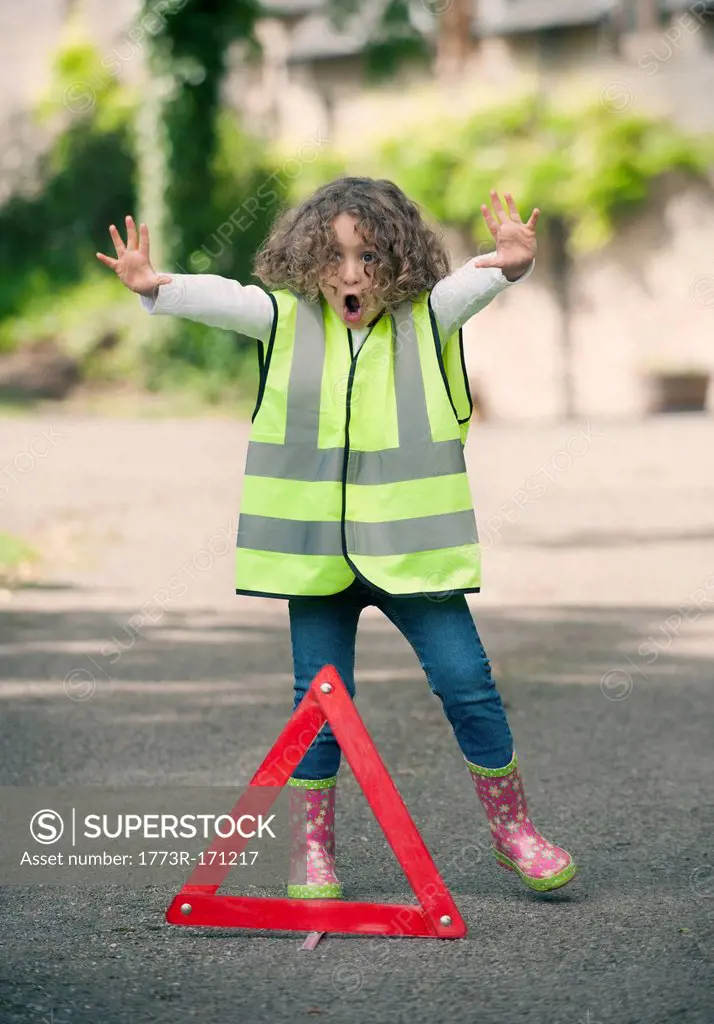 Girl playing traffic worker on rural road