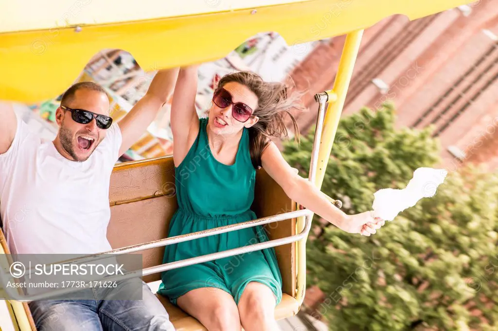 Couple riding amusement park ride