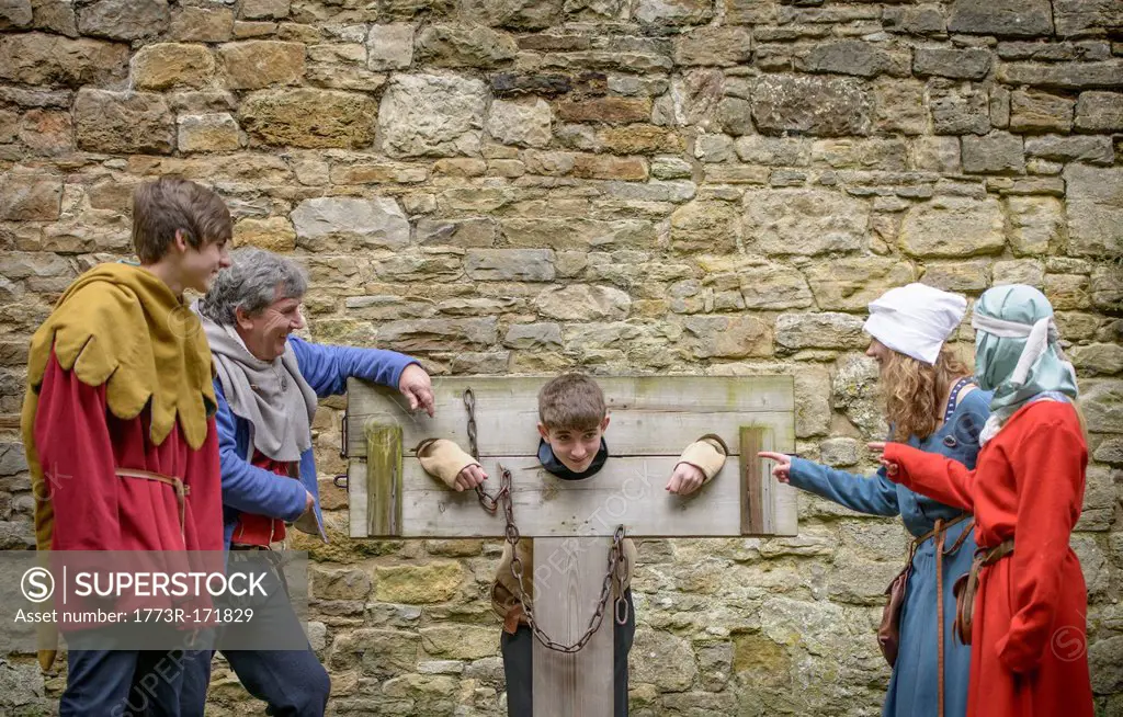 Students examining medieval stocks