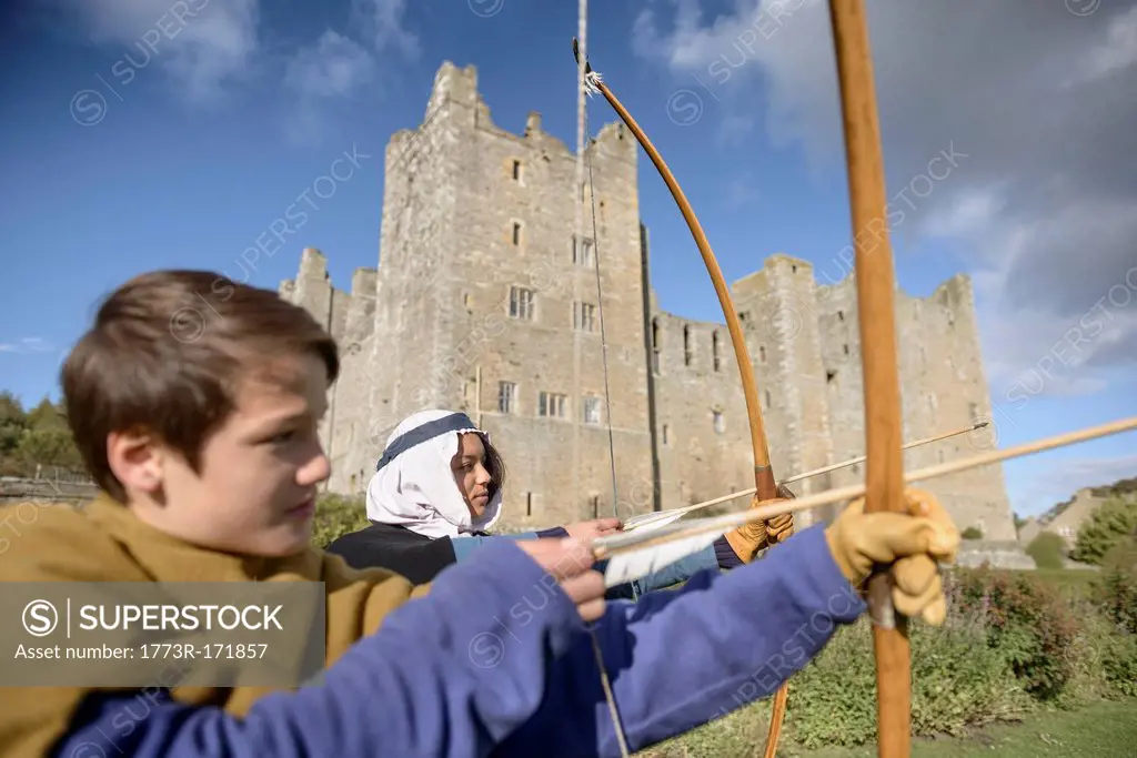 Students in period dress shooting arrows