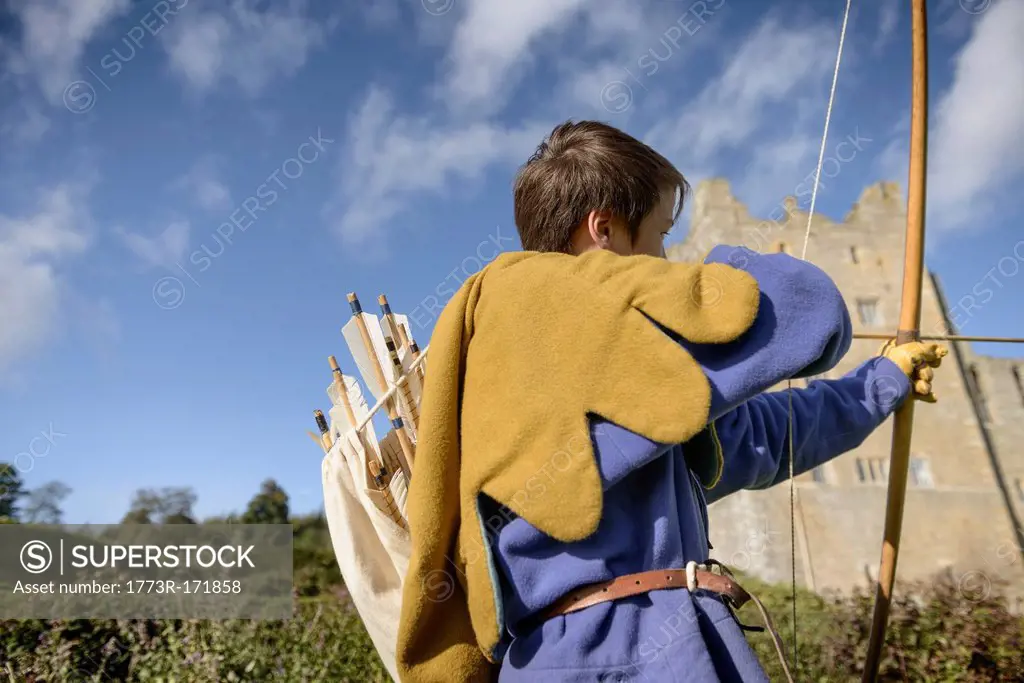 Student in period dress shooting arrow