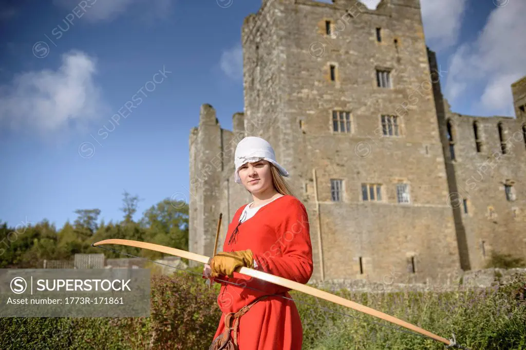 Student in period dress holding bow