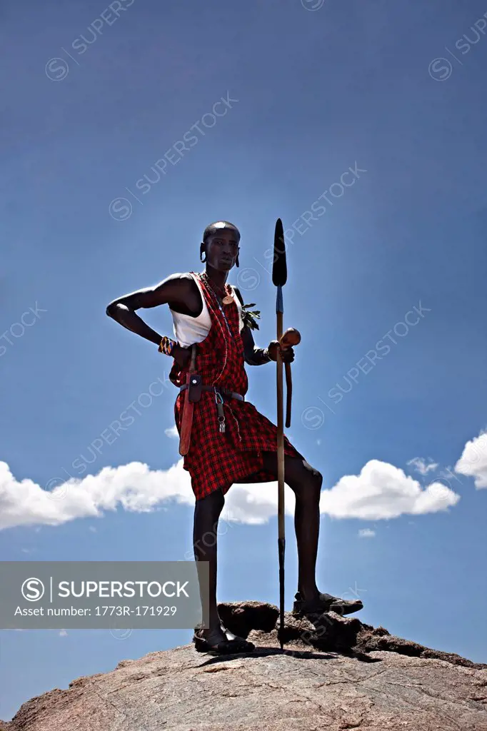 Maasai man standing on top of rock