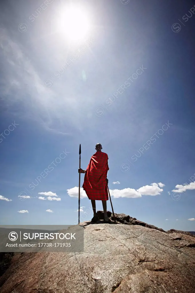 Maasai man standing on top of rock