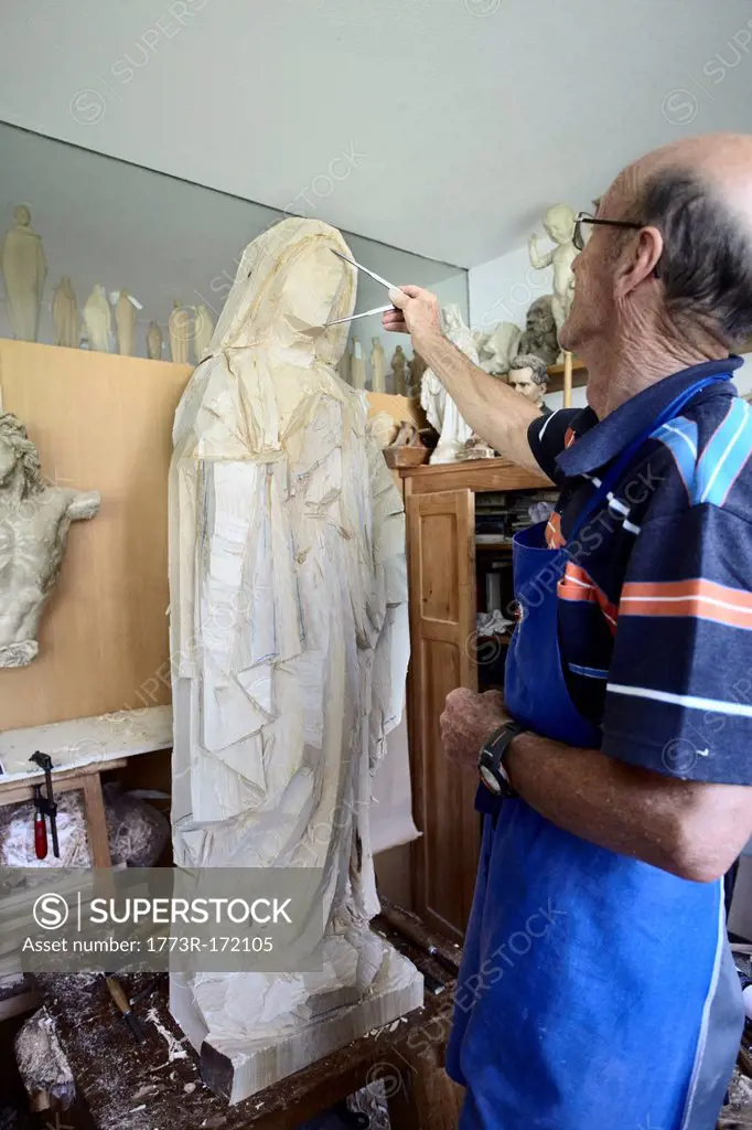 Sculptor admiring wood figure