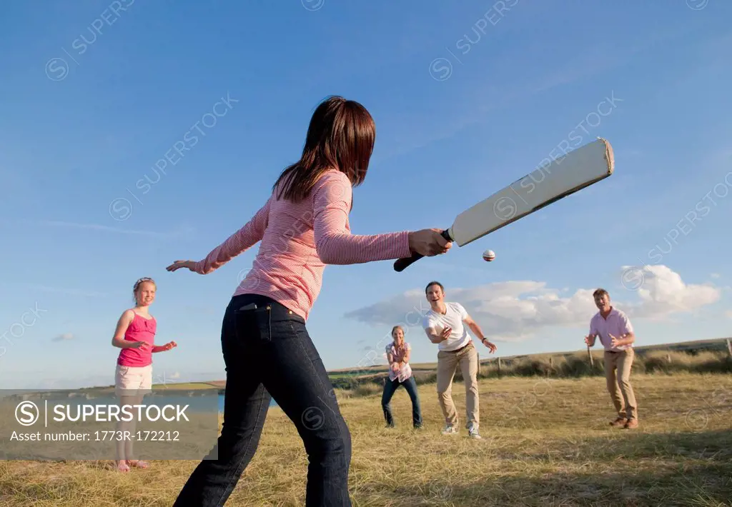 Family playing cricket together outdoors
