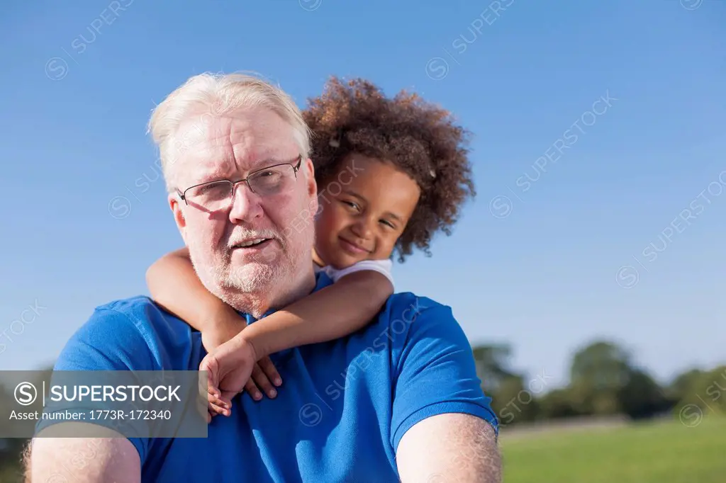 Girl hugging grandfather outdoors