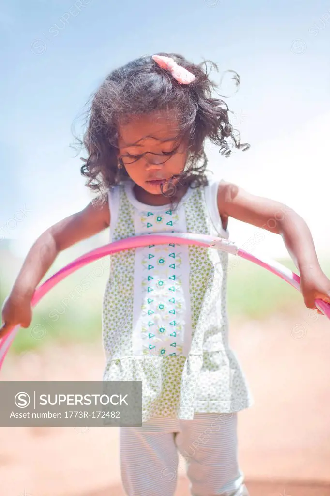 Girl playing with hula hoop outdoors