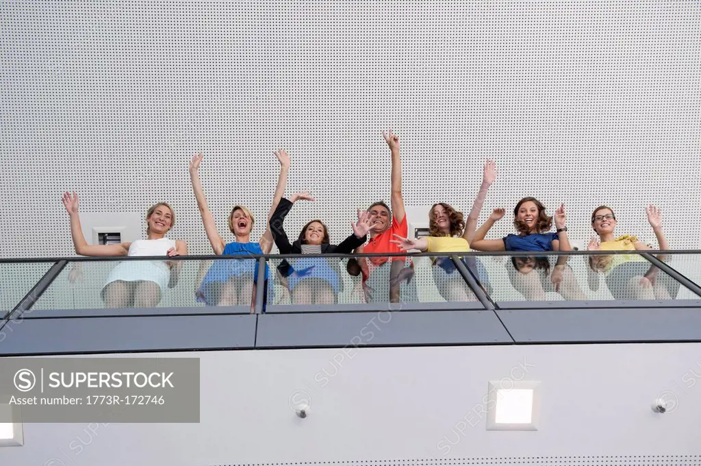 Business people waving from balcony