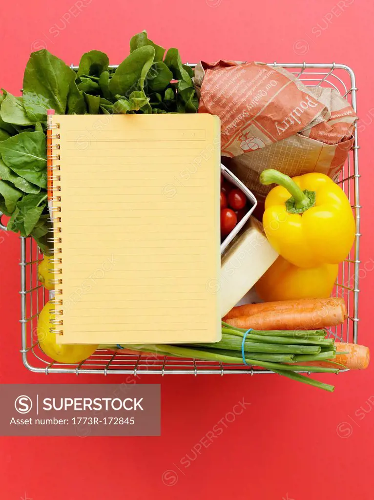 Basket with vegetables and notebook