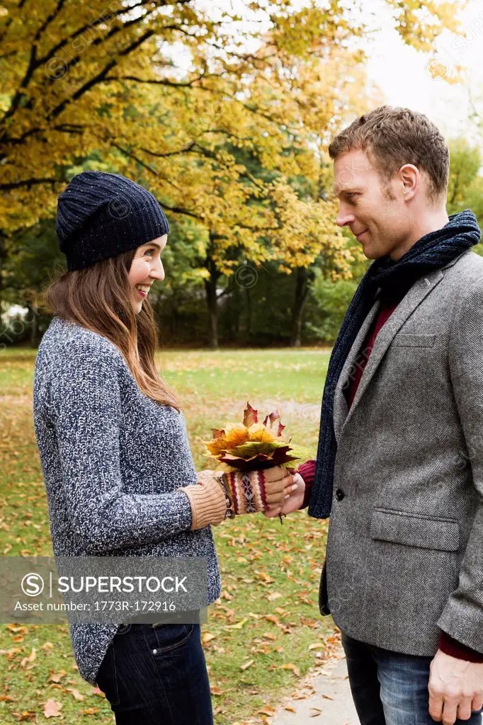 Couple holding autumn leaves