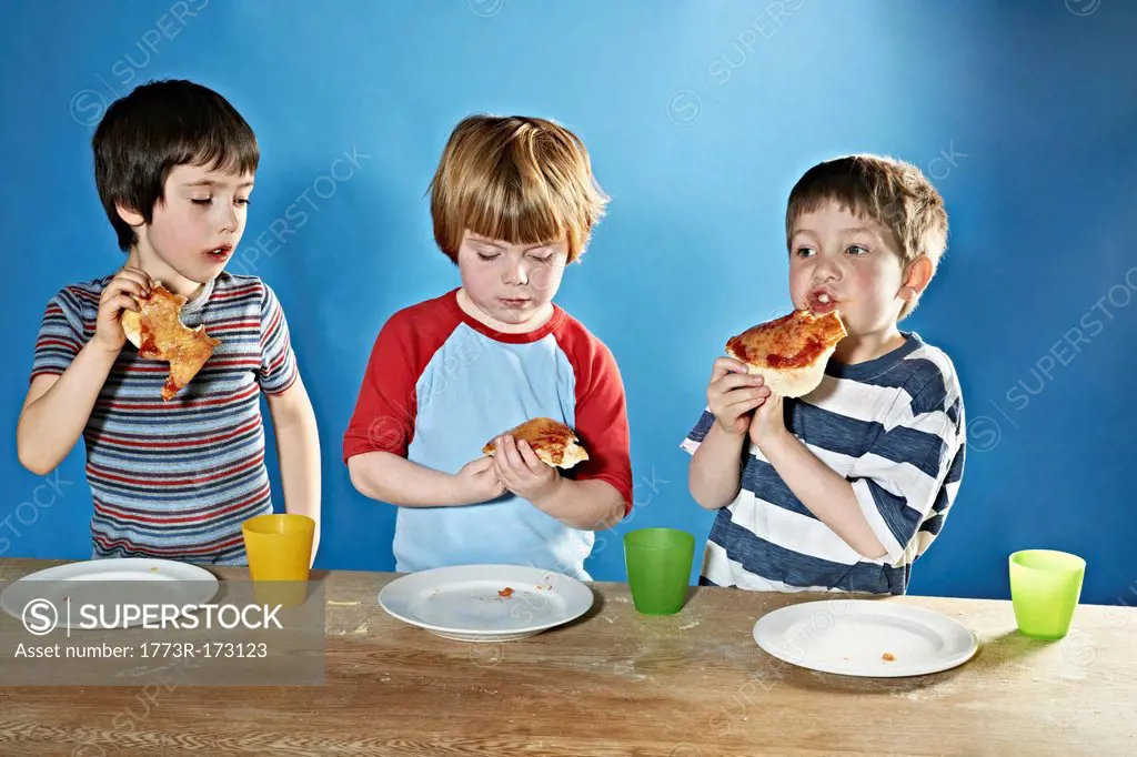 Boys eating pizza at table