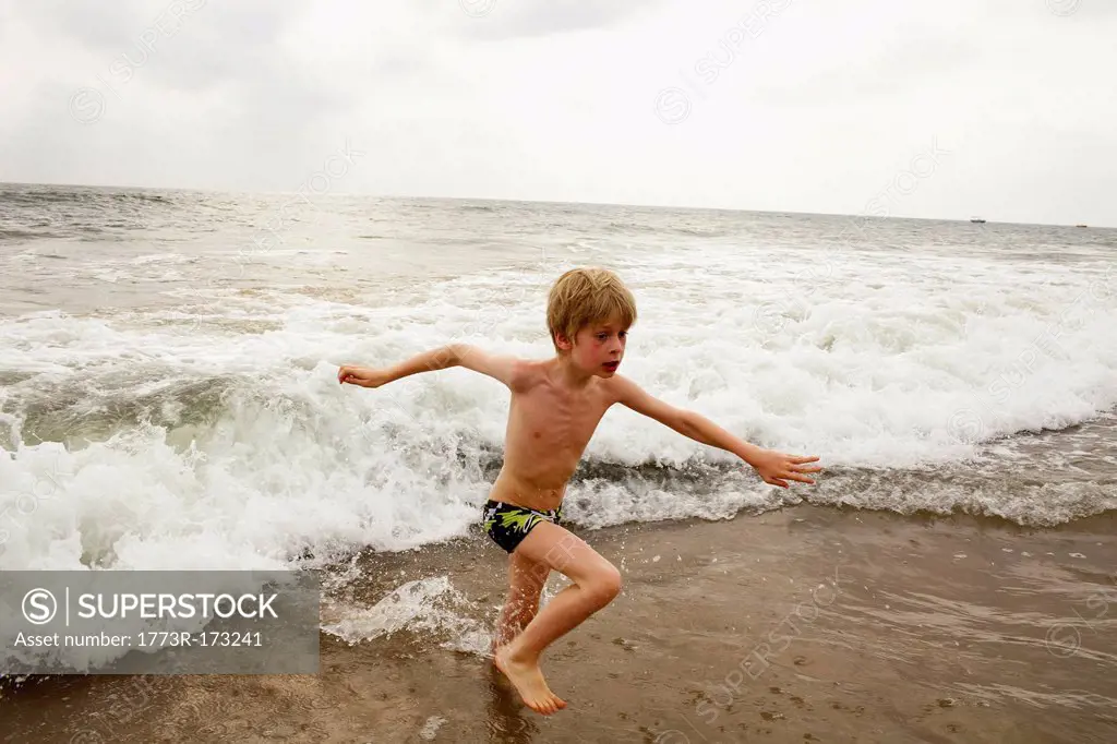Boy playing in waves on beach