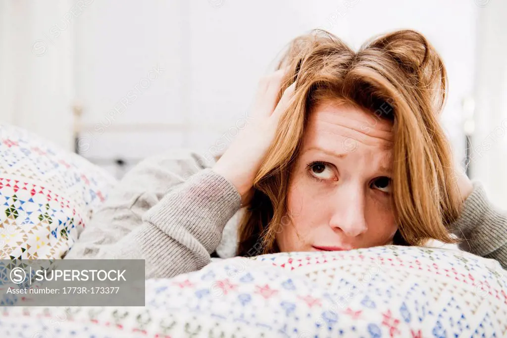 Woman ruffling her hair on bed