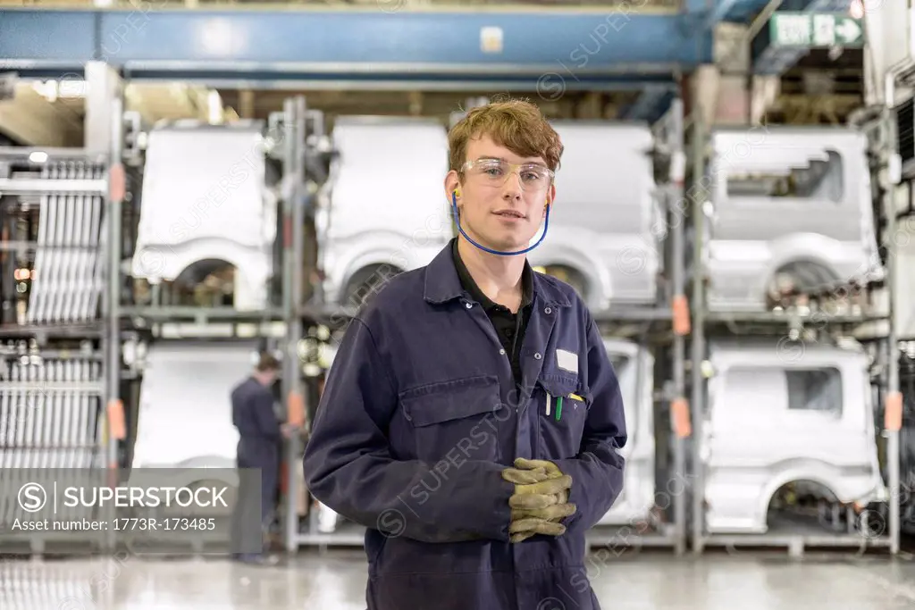 Apprentice standing in car factory