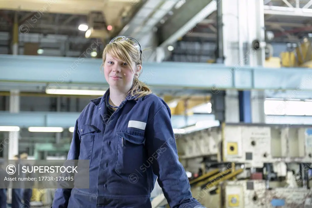Apprentice standing in car factory