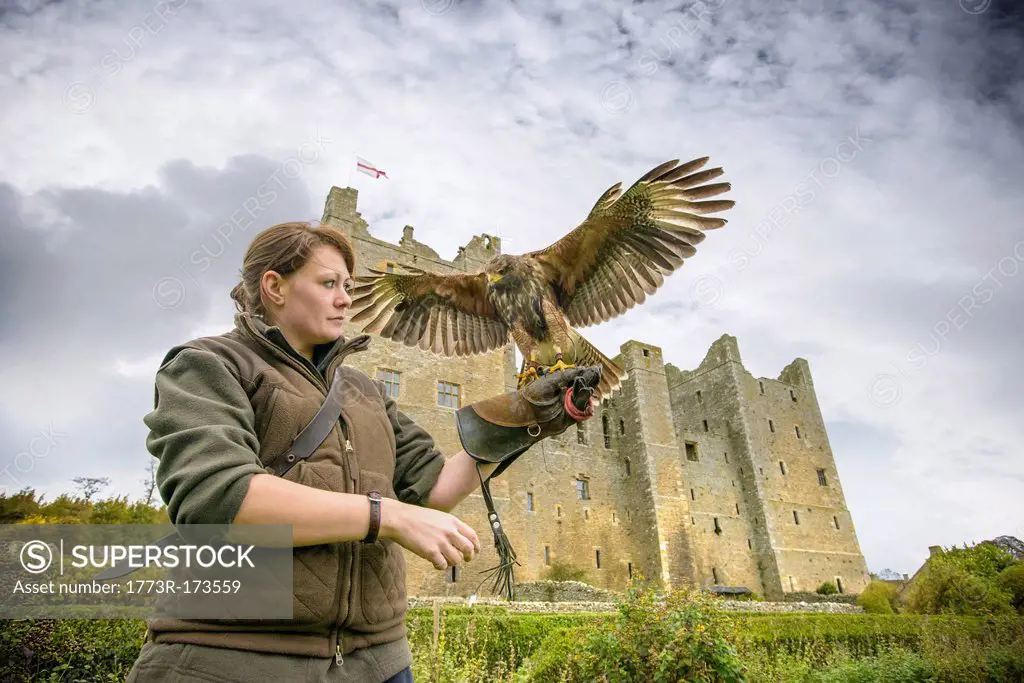 Woman with hawk and gauntlet outdoors
