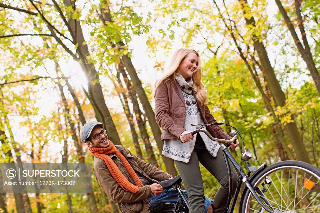 Couple riding bicycle in forest