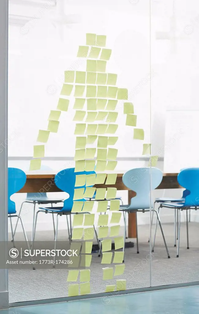 Post-Its stuck on glass wall in the shape of a human