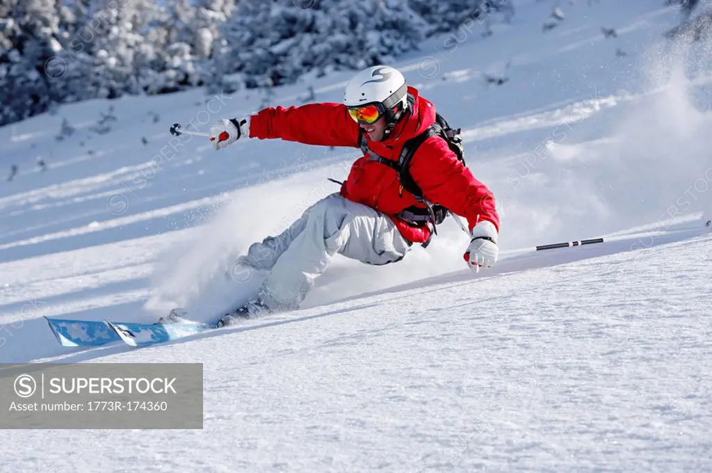man skiing down slope, smiling