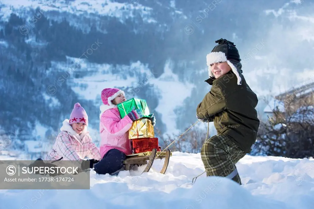 Children playing in snow with presents
